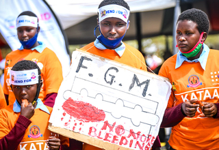 Students from Kisima Primary School hold placards calling for an end to FGM.